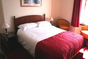a bedroom with a bed with a red and white blanket at Bimini House in Aberdeen