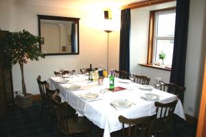 a table with a white table cloth and chairs and a mirror at Bimini House in Aberdeen +15 photos