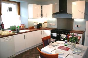 uma cozinha com uma mesa com copos de vinho em Bimini House em Aberdeen