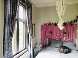 a bedroom with a bed and a pink curtain at 2-Bed Apartment overlooking the river in Avesta