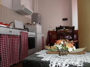 una cocina con una mesa con un ramo de flores. en Cà di Twergi, en Ornavasso