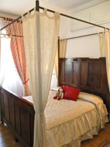 a bedroom with a canopy bed with a teddy bear on it at Cà di Twergi in Ornavasso