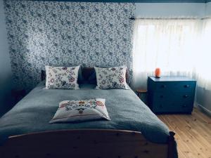 a bedroom with a bed with a blue wall at Liljekonvalj Cottage overlooking the river sauna in Avesta