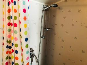 a shower stall with a shower curtain with polka dots at Liljekonvalj Cottage overlooking the river sauna in Avesta