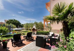 a patio with chairs and a fountain in a yard at Apartments Ante in Vodice