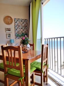 a dining room table and chairs with a table and a balcony at Infante - Primera Línea de Playa in Playa de Gandia