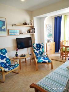 a living room with two chairs and a tv at BONAIRE - PRIMERA LÍNEA DE PLAYA in Playa de Gandia