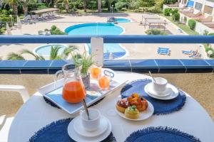 a table with a tray of orange juice and biscuits at Apartamentos Estival Park in La Pineda