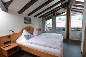 a bedroom with a bed and a large window at Ferienwohnungen Brigitte in Oberstdorf