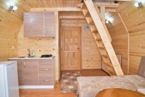 a kitchen with a staircase in a log cabin at Malena Plivsko Jezero Jajce in Jajce