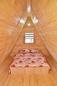 a bed in a log cabin with a window at Malena Plivsko Jezero Jajce in Jajce