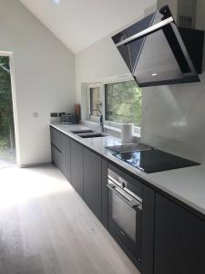 a kitchen with black cabinets and a sink at An Caisteal chalet in Crianlarich