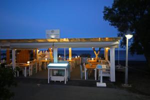 a gazebo with tables and chairs at night at Seaside Breeze in Kamari
