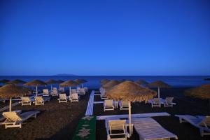 a group of chairs and umbrellas on a beach at Seaside Breeze in Kamari