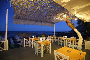 a restaurant with tables and chairs with the ocean in the background at Seaside Breeze in Kamari
