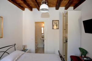 um quarto branco com uma cama e uma casa de banho em Casa dea corte apartment em Veneza