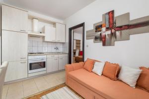 ein Wohnzimmer mit einem Sofa und einer Küche in der Unterkunft Pansion Kiko in Starigrad-Paklenica