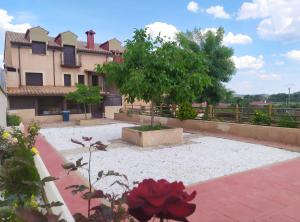 a courtyard with a house and a red rose at Tejadillos - Apartamentos El Cabo in Las Majadas
