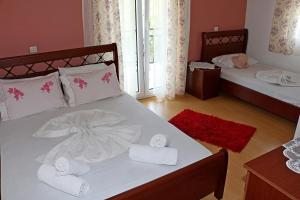 een slaapkamer met 2 bedden en handdoeken bij Kristal Hotel in Prinos