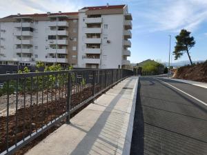 a sidewalk with a fence next to a building at Sunny Hill Suite Ljubovic in Podgorica