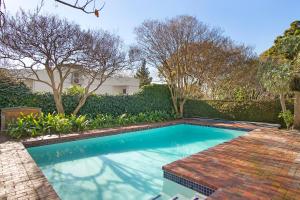 een zwembad in een tuin met bomen bij Magnolia Cottage in Kaapstad