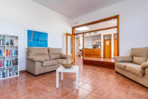 a living room with two couches and a table at Apartamentos Vistapicas in Cala en Blanes