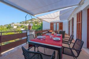 a patio with a table and chairs on a balcony at Cas Padri Vacation Home Alcina Vacations vistas al Castillo de Capdepera in Capdepera