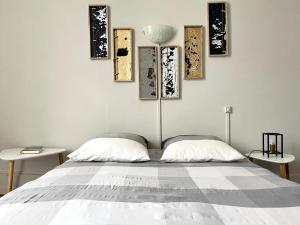 a bedroom with a bed with four paintings on the wall at Appartement standing in Nevers