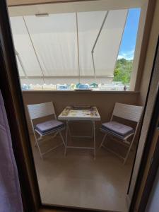 a table and two chairs in a room with a window at Perla Apartment Postira Island of Brač in Postira