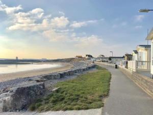 a walkway next to a beach with houses and condos at Inviting 3-Bed Caravan in Porthcawl in Porthcawl