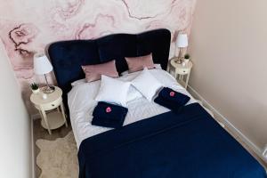 um quarto com uma cama azul com almofadas em Apartament Bella Rosa z podziemnym parkingiem em Kielce