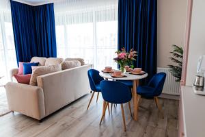 a living room with a couch and a table and chairs at Apartament Bella Rosa z podziemnym parkingiem in Kielce