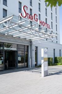 una señal para un hotel estrella frente a un edificio en Star G Hotel Premium München Domagkstraße, en Múnich