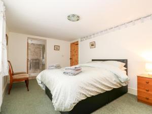 a bedroom with a large bed and a chair at The Old Farm Cottage in Louth