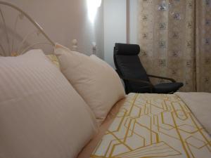 a bedroom with a bed with a chair next to it at Apartment на Полковой в центре in Omsk