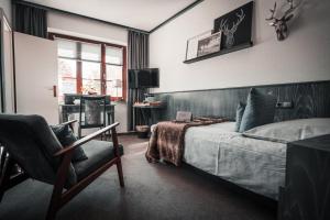 a bedroom with a bed and a chair at Sommers Hotel Altes Posteck in Reichenbach im Vogtland