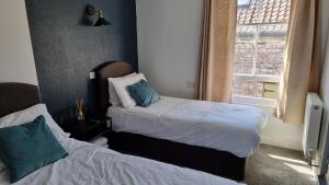 a bedroom with two beds and a window at The Portcullis in Bristol