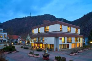 ein Gebäude in einer Stadt mit einem Berg im Hintergrund in der Unterkunft Hotel Garni am Goetheplatz in Bad Münster am Stein-Ebernburg