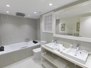 a bathroom with two sinks and a tub and a toilet at Sitges Spaces Mediterranean Apartments 5 Bedrooms, 4 Bathrooms, 75M2 Terrace, Centre Sitges- Sleeps 11 in Sitges +13 photos