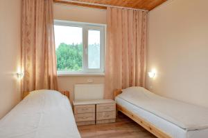 um quarto com 2 camas e uma janela em Karumetsa Apartment em Otepää