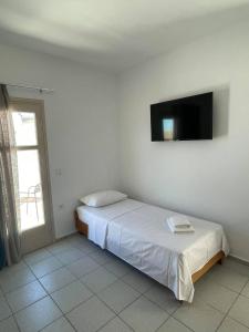 a bedroom with a bed and a flat screen tv at Coralli Beach Hotel in Kokkini Khanion