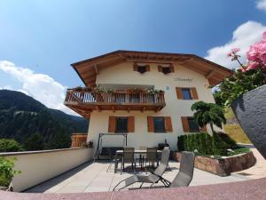 Casa con balcón con mesa y sillas en Mesnerhof, en Lauregno