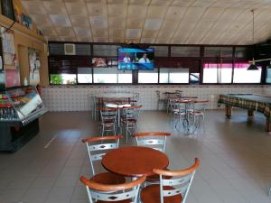 a restaurant with tables and chairs and a tv at Alojamentos Martinho in Quintas