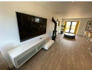a living room with a large flat screen tv on a wall at Immaculate 4-Bed Cottage in Lincoln in Sudbrooke