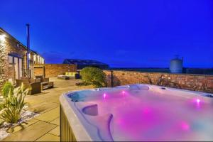 a hot tub in a backyard at night at Immaculate 4-Bed Cottage in Lincoln in Sudbrooke