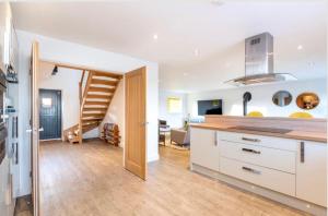 a kitchen with white cabinets and a staircase in a room at Immaculate 4-Bed Cottage in Lincoln in Sudbrooke