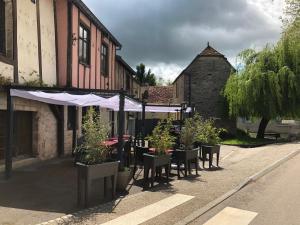 eine Straße mit Tischen und Stühlen und ein Gebäude in der Unterkunft Auberge du Renard'eau in Bèze