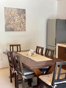 a dining room table with chairs and a refrigerator at Kuća za odmor "Villa Oliva" in Ivan Dolac