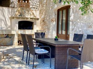 a table and chairs in front of a fireplace at Kuća za odmor "Villa Oliva" in Ivan Dolac