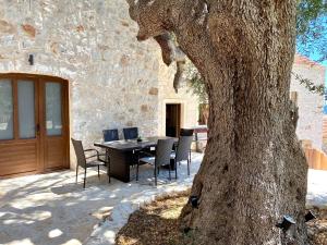 a table and chairs sitting next to a tree at Kuća za odmor "Villa Oliva" in Ivan Dolac